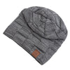 A gray knit beanie with a diamond pattern and a brown leather tag.