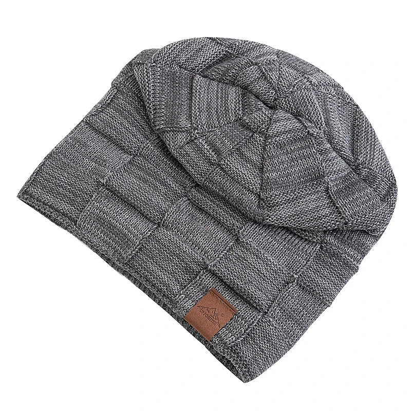 A gray knit beanie with a diamond pattern and a brown leather tag.