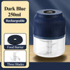 A dark blue blender jar with a clear lid and three blades is shown on a wooden surface.