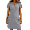 A woman wearing a gray lightweight cotton-linen short sleeve dress with a collar and front zipper and side pockets.