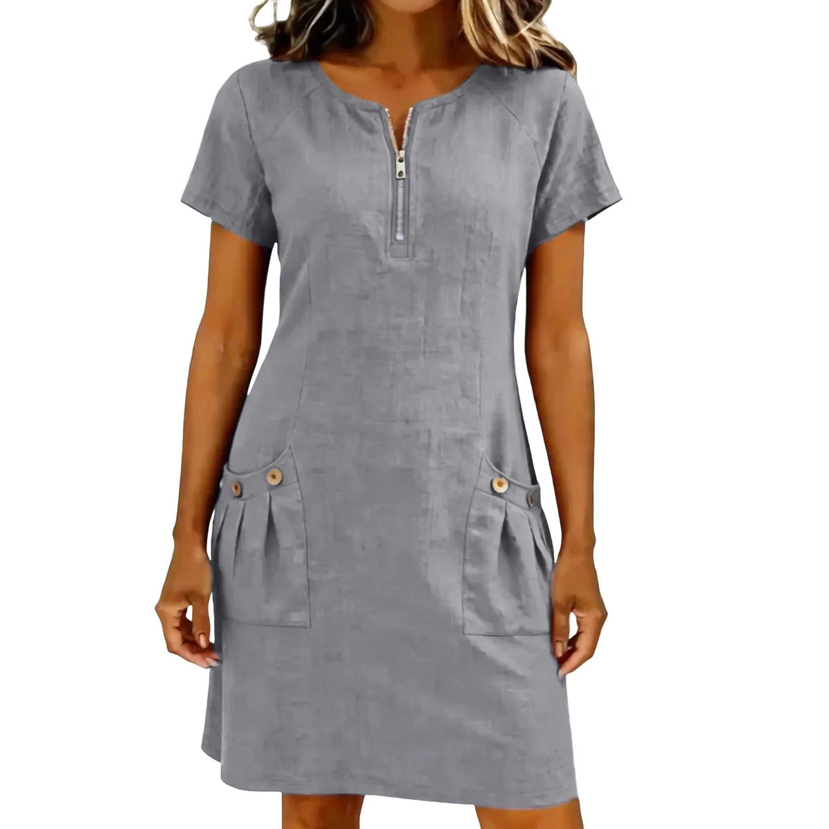 A woman wearing a gray lightweight cotton-linen short sleeve dress with a collar and front zipper and side pockets.