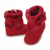 A pair of red baby winter ankle boots with plush lining and a bow detail.