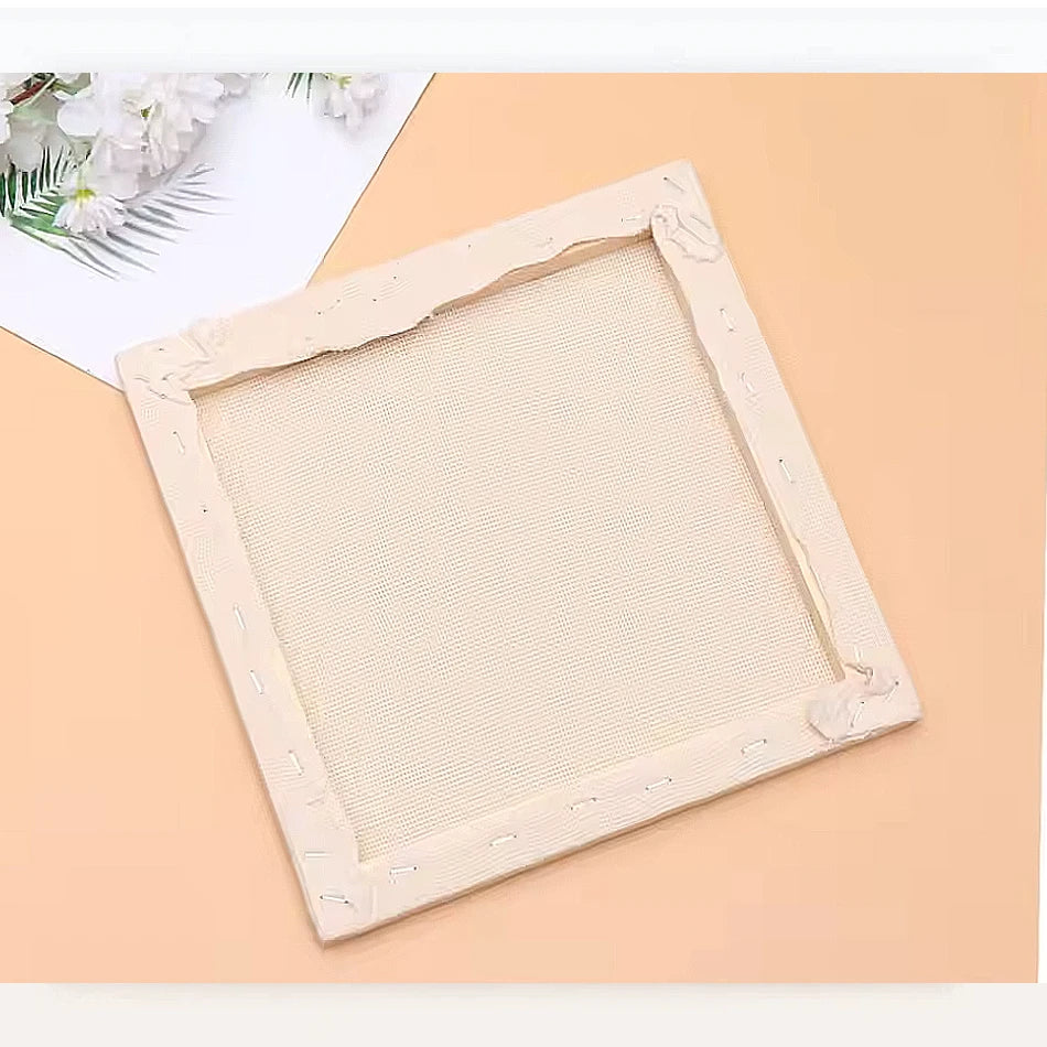 Un bastidor de bordado cuadrado con borde beige claro, listo para la técnica de punch needle.