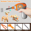 A hand holds an orange power tool assembling small parts, alongside various tools like pliers, hex wrenches, and a drill kit.