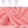 Et lilla badehåndkle som er drapert over en persons arm, og fremhever den myke teksturen og designet.