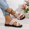 A woman wears pink breathable mesh flat sandals with a cushioned sole against a white background.