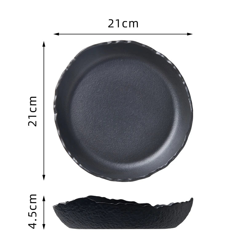 Svart keramisk dessertbolle med bred kant og flat bunn, vist fra topp-, side- og profilperspektiv.