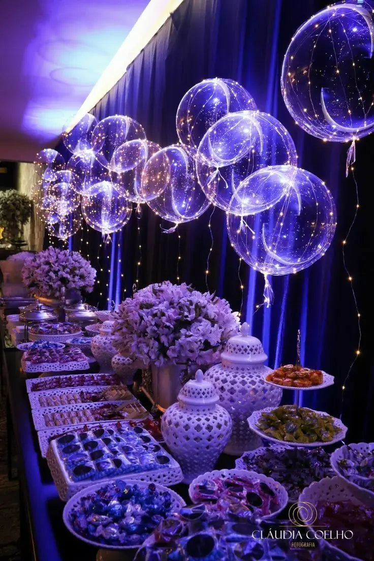 A display of blue LED light-up balloons with pre-strung lights hanging against a dark blue backdrop.
