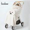 A beige dinosaur-themed baby windproof carrier and stroller blanket with a light wooden handle.