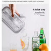 A hand is shown using a portable ice tray that is also a kettle to make ice cubes.