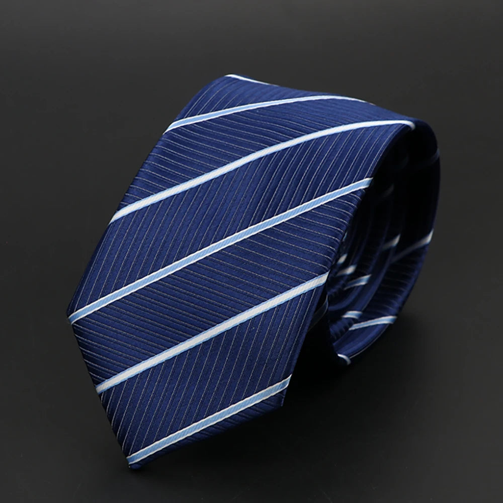Corbata azul oscuro con rayas blancas finas, en diagonal sobre fondo oscuro.