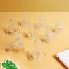 Una colección de tetinas y anillos de silicona transparente para biberón sobre una superficie amarilla.