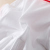White cotton dress with a turn-down collar and red trim, shown in a draped fabric.