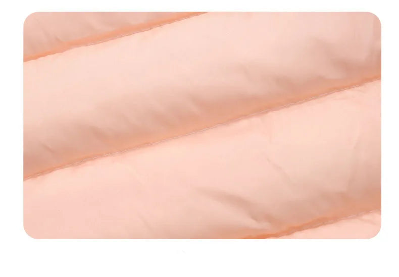 A close-up of a light pink kids' hooded down jacket fabric with diagonal stitching.