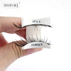 A hand holds a pair of magnetic eyelash extensions with an upward and downward marking for application.