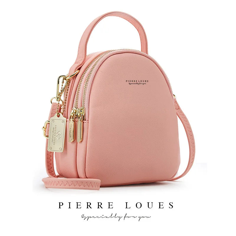 Rosa Leder-Minirucksack von Pierre Loueuses mit Goldbeschlägen und geflochtenem Riemen.