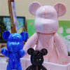 A collection of DIY paintable bear figurines in blue and pink colors displayed in a white container.