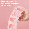 A hand is rinsing a pink silicone popsicle mold under running water to clean it.