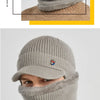 A model wearing a grey knit beanie hat and matching scarf in a winter fashion look.