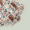 A floral print baby romper featuring brown cow print patterns and a matching headband.