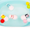 A set of cute duck and penguin bath toys with water spray fun floating in clear blue water.