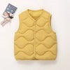 A yellow quilted vest for a child is shown next to a small stuffed animal.
