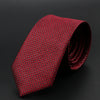 Corbata roja estampada enrollada, con diseño geométrico repetitivo.