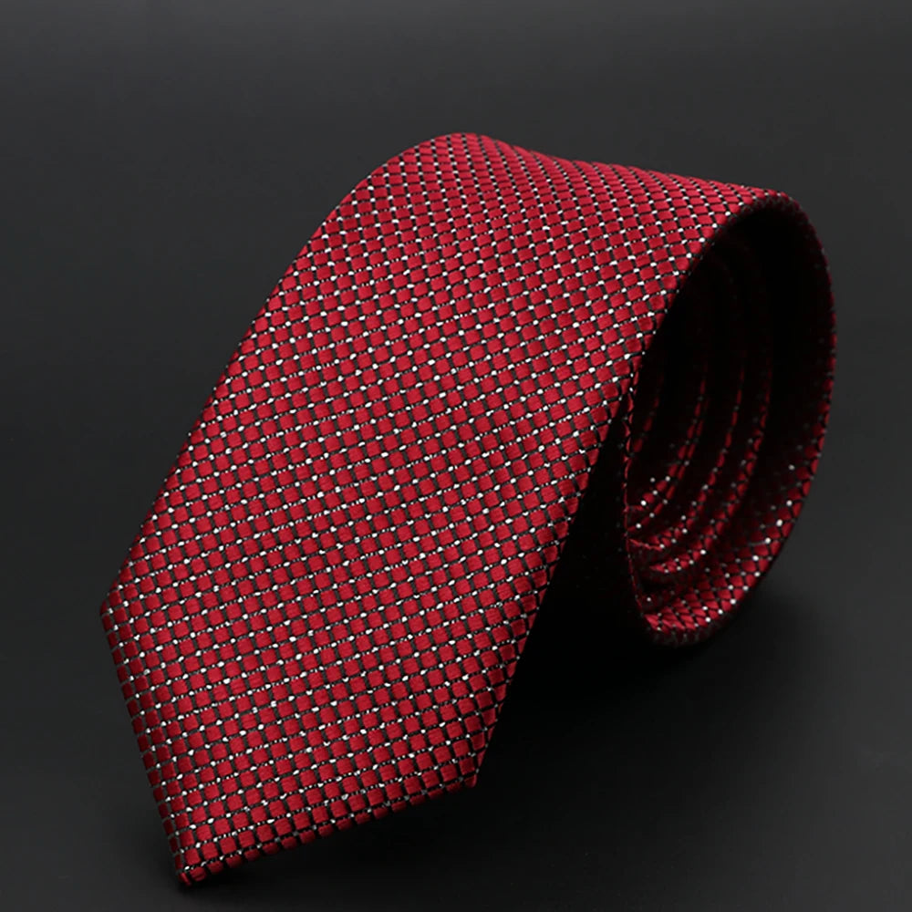 Corbata roja estampada enrollada, con diseño geométrico repetitivo.