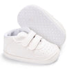 White soft sole baby pre-walker sneakers with a detached sole plate shown next to the shoe.