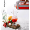 A hand pours liquid from a portable ice cube tray mold into a glass, demonstrating the product's use.