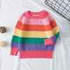 A girls' rainbow striped knit sweater in various pastel colors laid flat on a white surface.