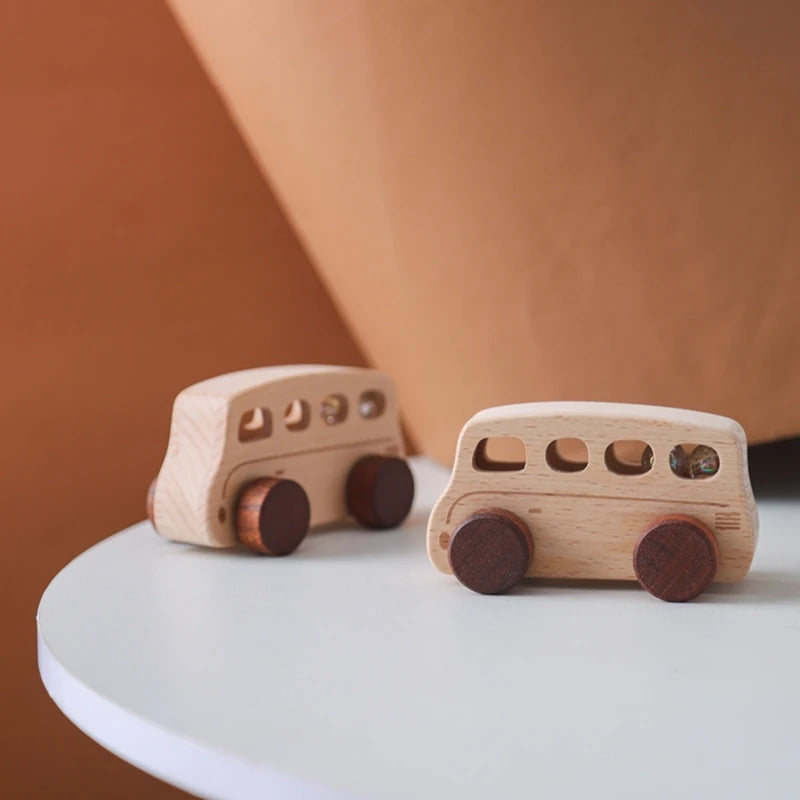 A light wood hand-pushed cart toy for toddlers resting on a white surface.