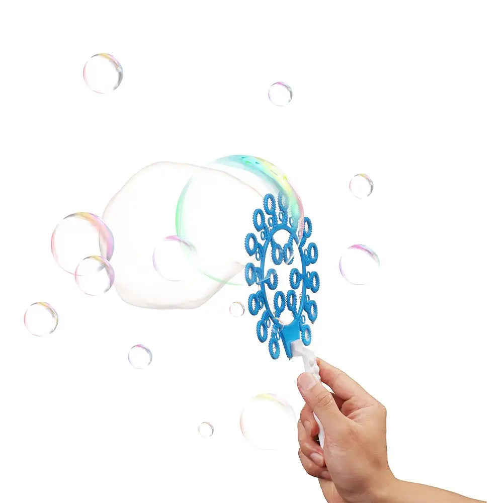 A hand is blowing blue bubbles from a bubble wand party set, with several other bubbles floating in the air.