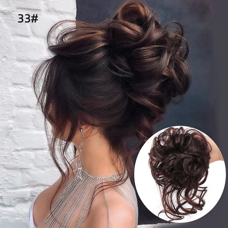 Un moño de cabello castaño oscuro con rizos despeinados sujeto con una banda elástica.