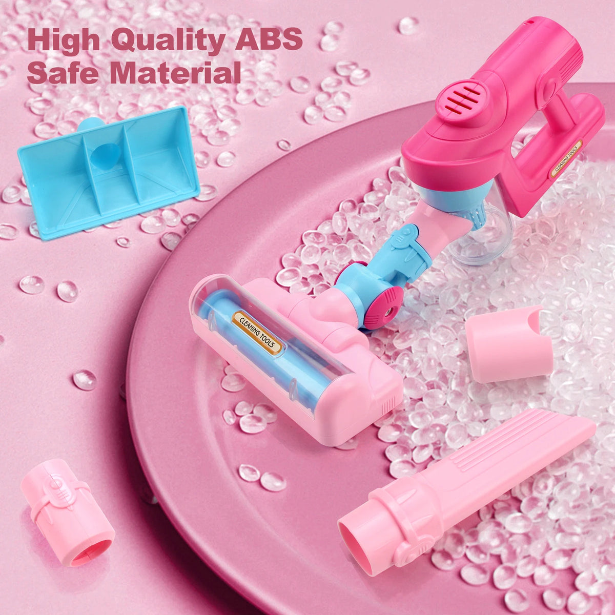A pink toy vacuum cleaner is shown on a pink plate with clear beads, demonstrating a safe material product.