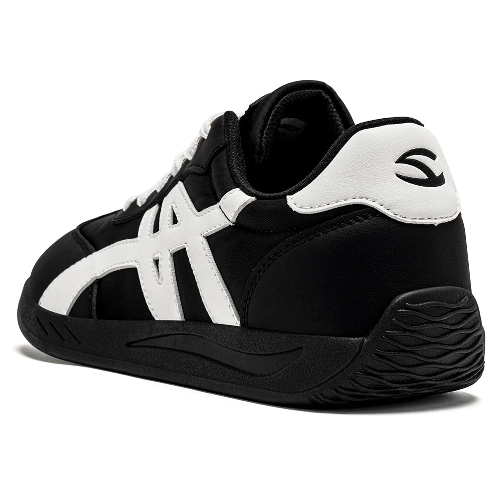 Minimalistischer Sneaker in Schwarz-Weiß von der Seite, mit breiter Zehenbox und schlichtem Design.