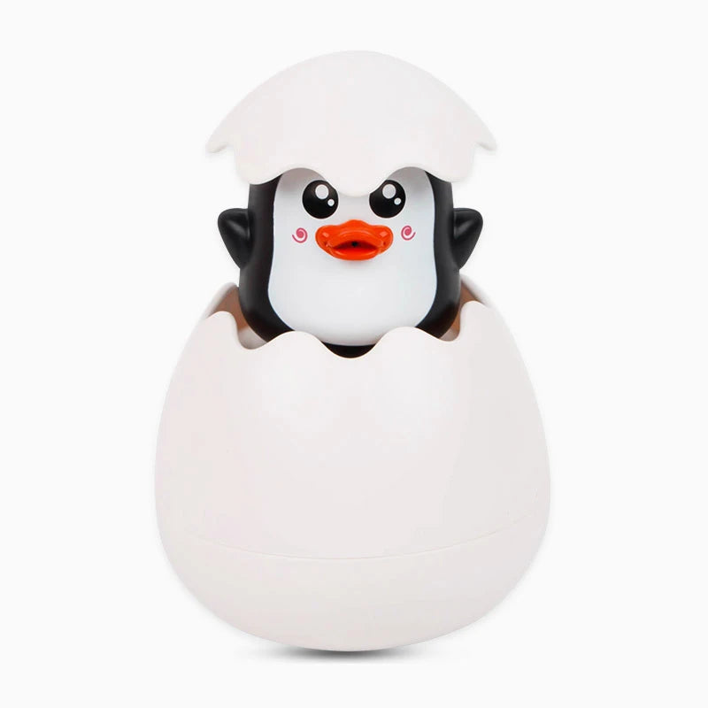 A white bath toy shaped like a penguin with an orange beak is nestled inside a larger white egg-shaped container.