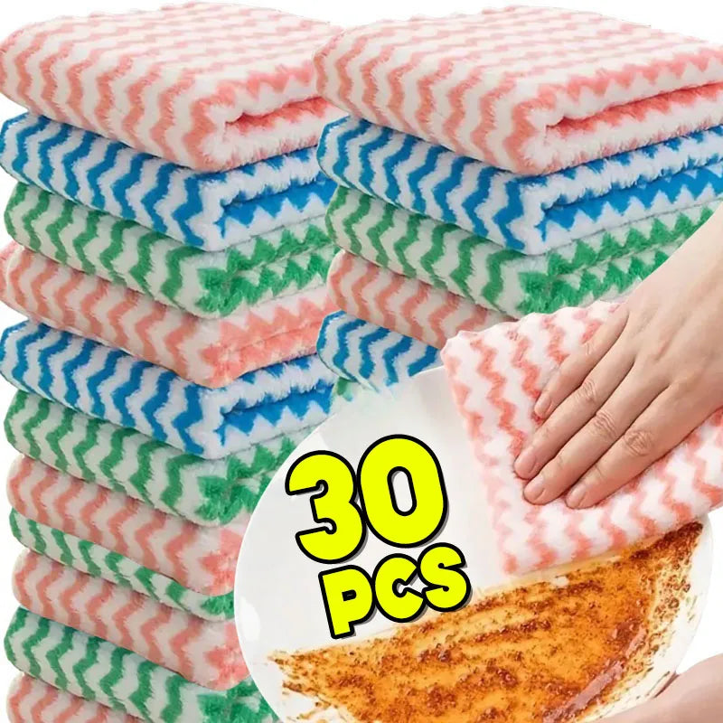 Un montón de paños de limpieza de forro polar coral rosa y verde con rayas azules, junto a un trozo de comida naranja.