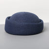 A navy blue straw pillbox sun hat with a wide brim shown from above.