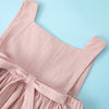 A light pink sleeveless cotton dress for a toddler girl, shown flat lay against a pale blue background.
