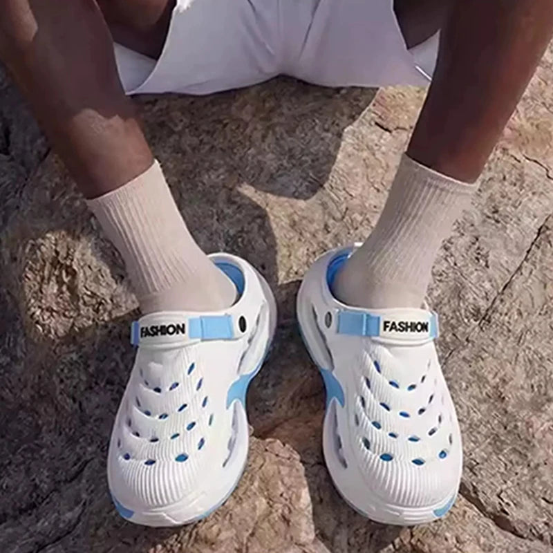 A pair of white and light blue men's EVA slip-on sandals with cushioned platform soles worn by a person.