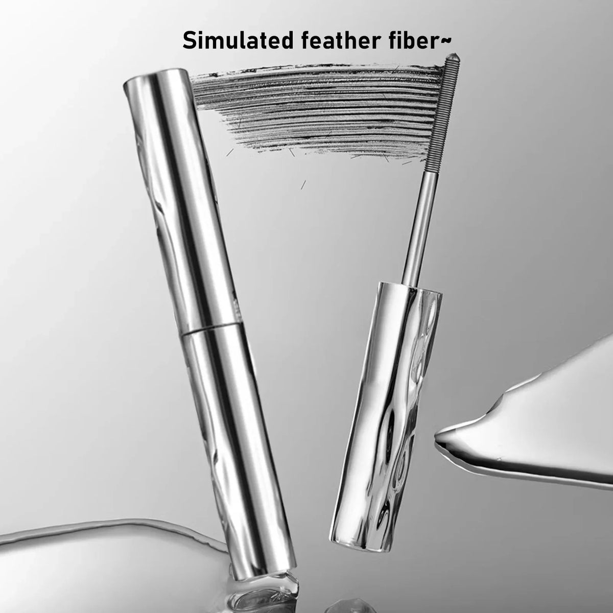 A close-up view of a silver waterproof volumizing mascara with a defining brush, showing the bristles and product design.