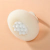 A round, light beige bath sponge with a suction cup attachment is shown against a neutral background.