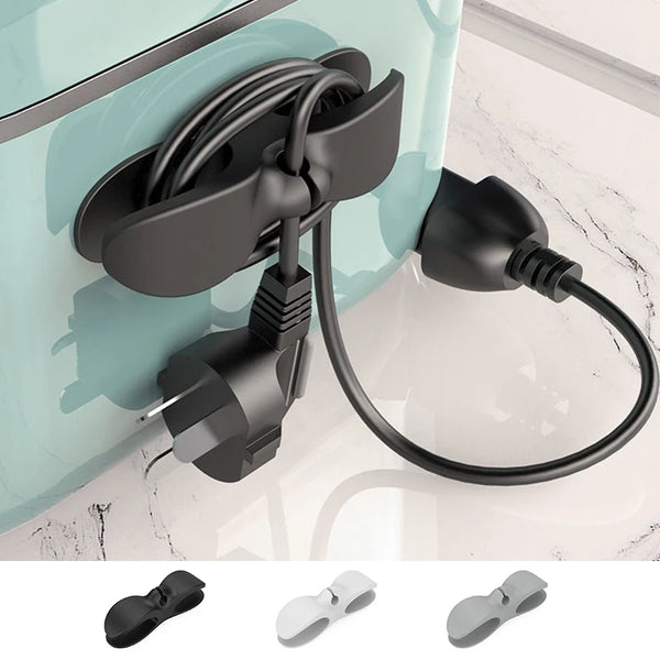A black cable management clip with an adhesive mount is shown attached to a light blue surface.