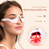 A woman is using a white red light eye massager device for eye therapy.