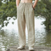 A person is wearing beige men's cotton linen casual jogger pants outdoors.