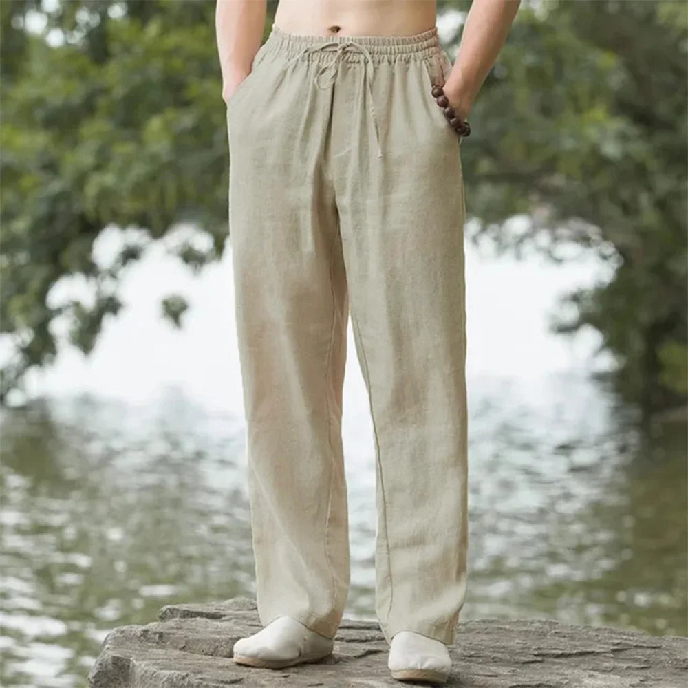 A person is wearing beige men's cotton linen casual jogger pants outdoors.