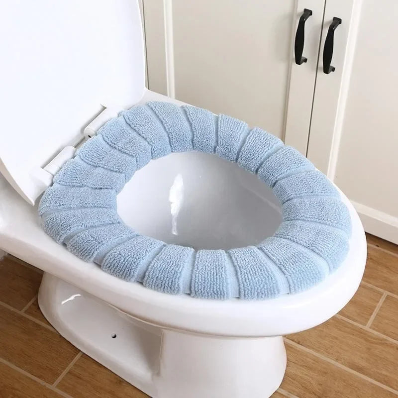 A white toilet with a light blue, textured acrylic seat cover installed.