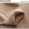 Close-up of a beige ribbed knit turtleneck sweater folded on a wooden surface.