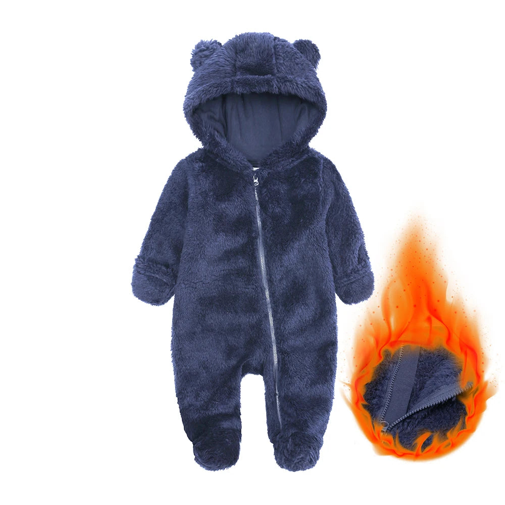 A dark blue fuzzy baby fleece hooded romper with a zipper, shown next to a small flame.